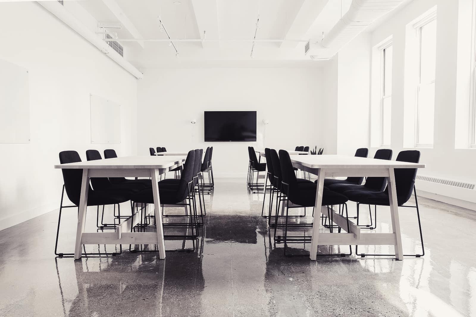Meeting tables and chairs in a bright, empty boardroom