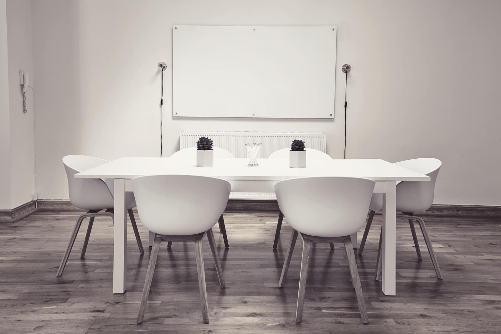A white meeting room with a table and chairs