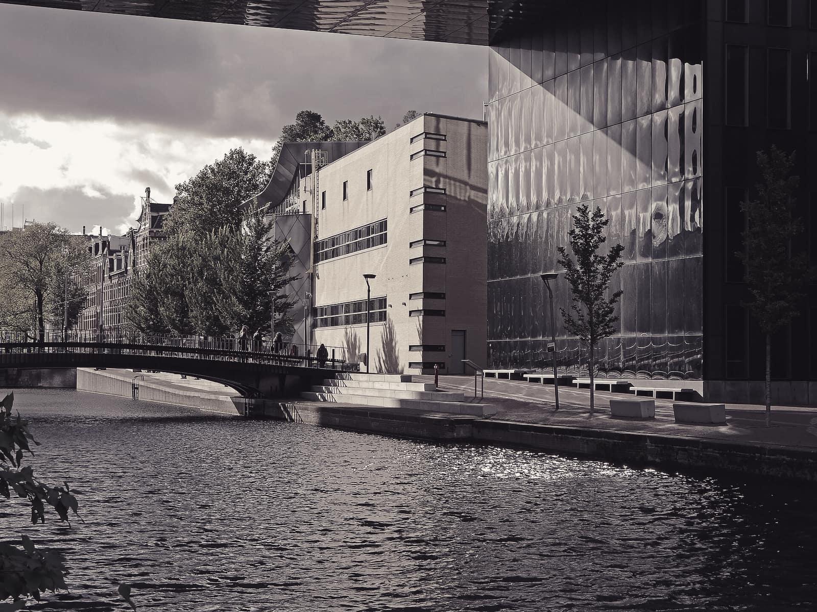 Modern buildings and a bridge along a canal