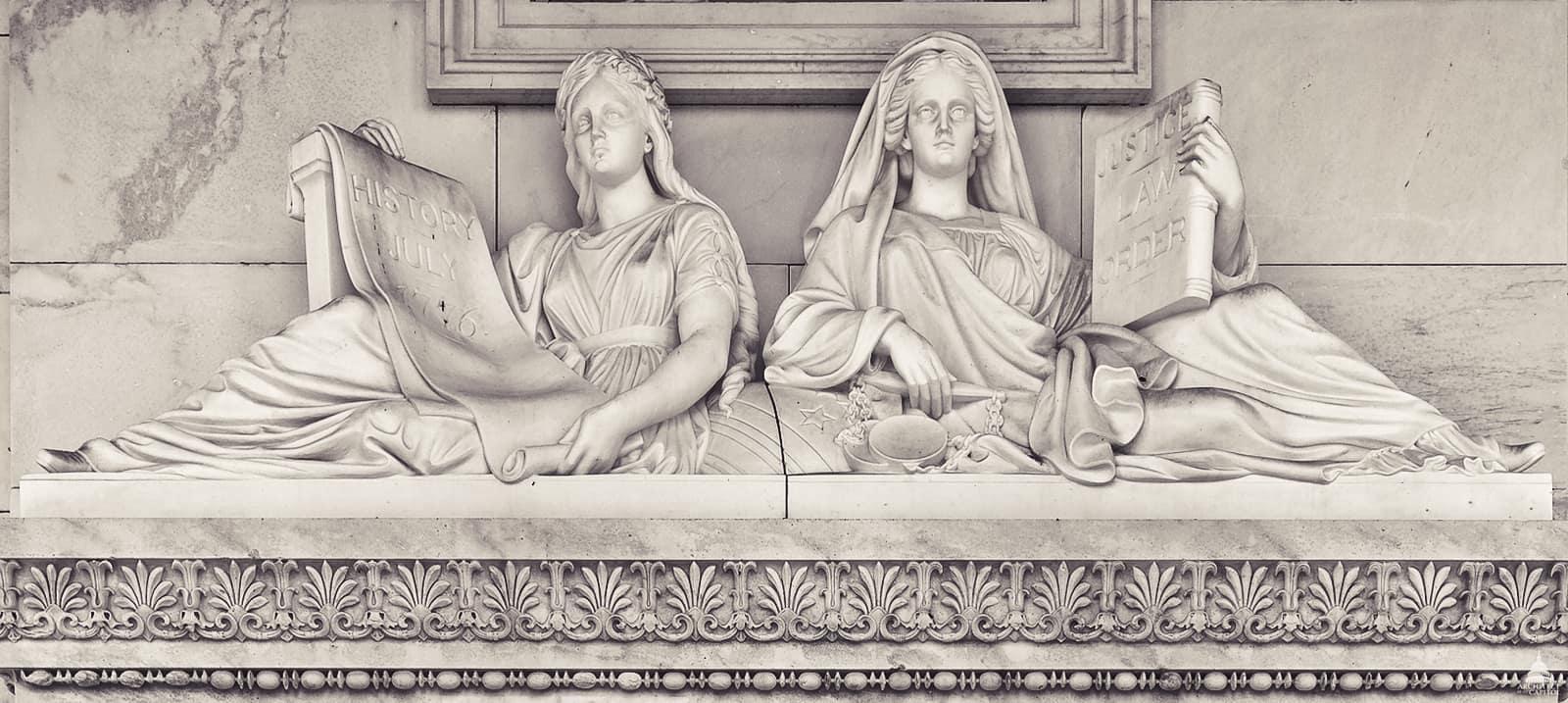 Classical stone relief sculpture of Justice and History