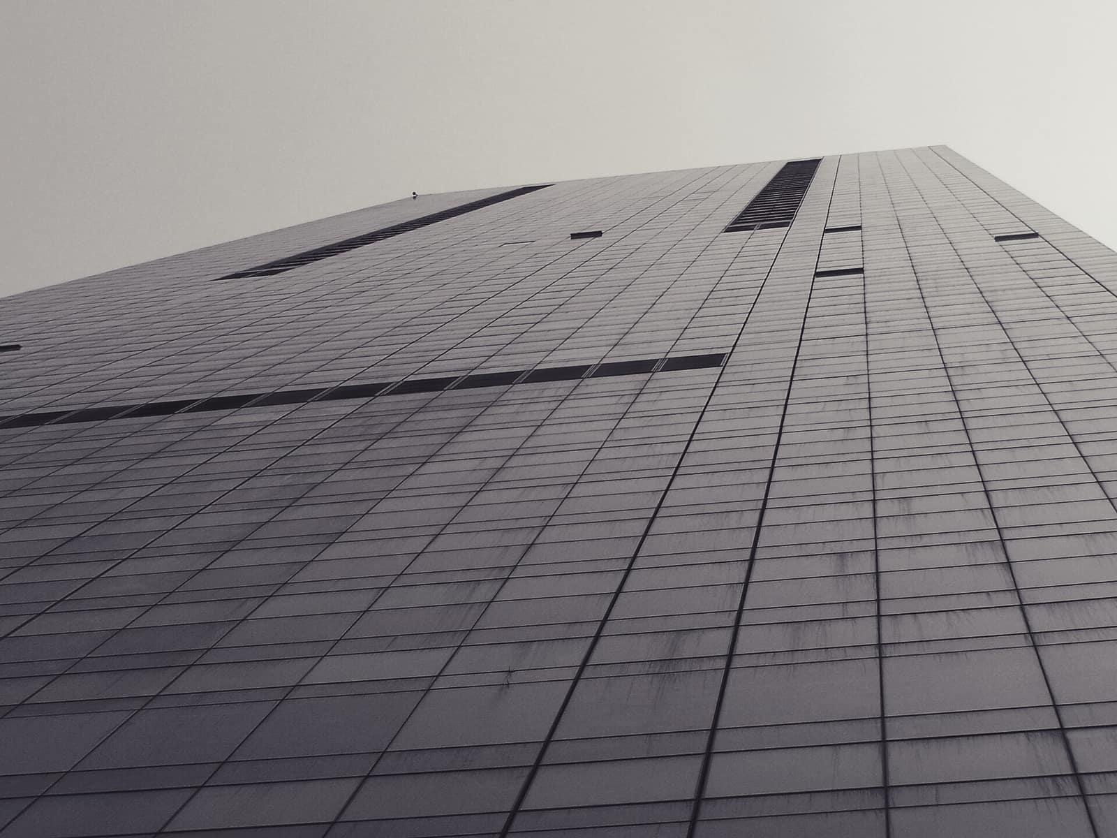 Looking up the glass and steel facade of an office tower