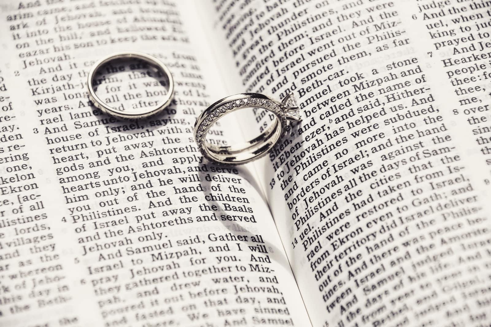 Two wedding rings resting on an open book